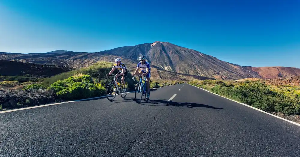 Cyclist on a scenic mountain road in Tenerife, destination for our bike transport service